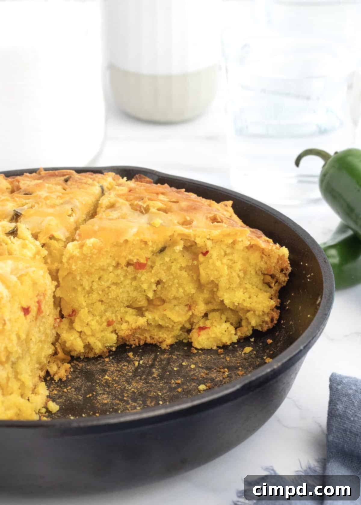 A large pan of Cheesy Corn Cornbread served with a spoon, ready to be dished out.
