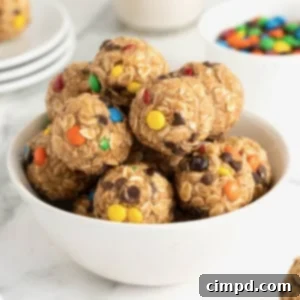 No-Bake Monster Cookie Bites 13 A white bowl of monster cookie balls on a white marble counter, perfectly presented.