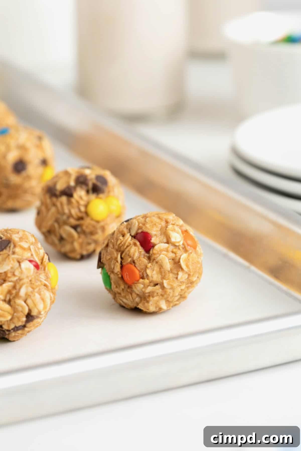 No-Bake Monster Cookie Bites 5 A parchment-lined aluminum baking sheet neatly filled with an array of monster cookie balls, awaiting refrigeration.