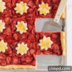 Summer Strawberry Slab Pie 12 A vibrant Strawberry Slab Pie baked in an aluminum rimmed baking sheet, showcasing its golden crust and lush red filling.