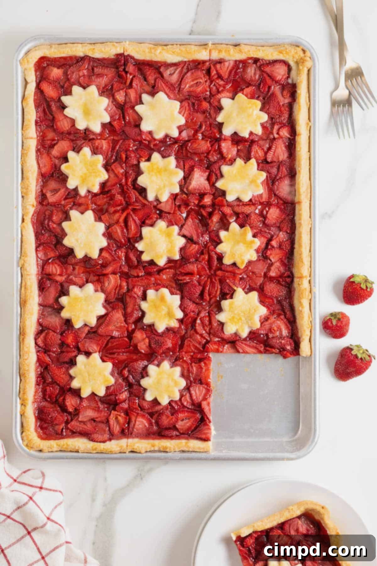 Summer Strawberry Slab Pie 10 A delicious Strawberry Slab Pie, with a perfectly cut piece removed, highlighting its generous filling and golden crust.