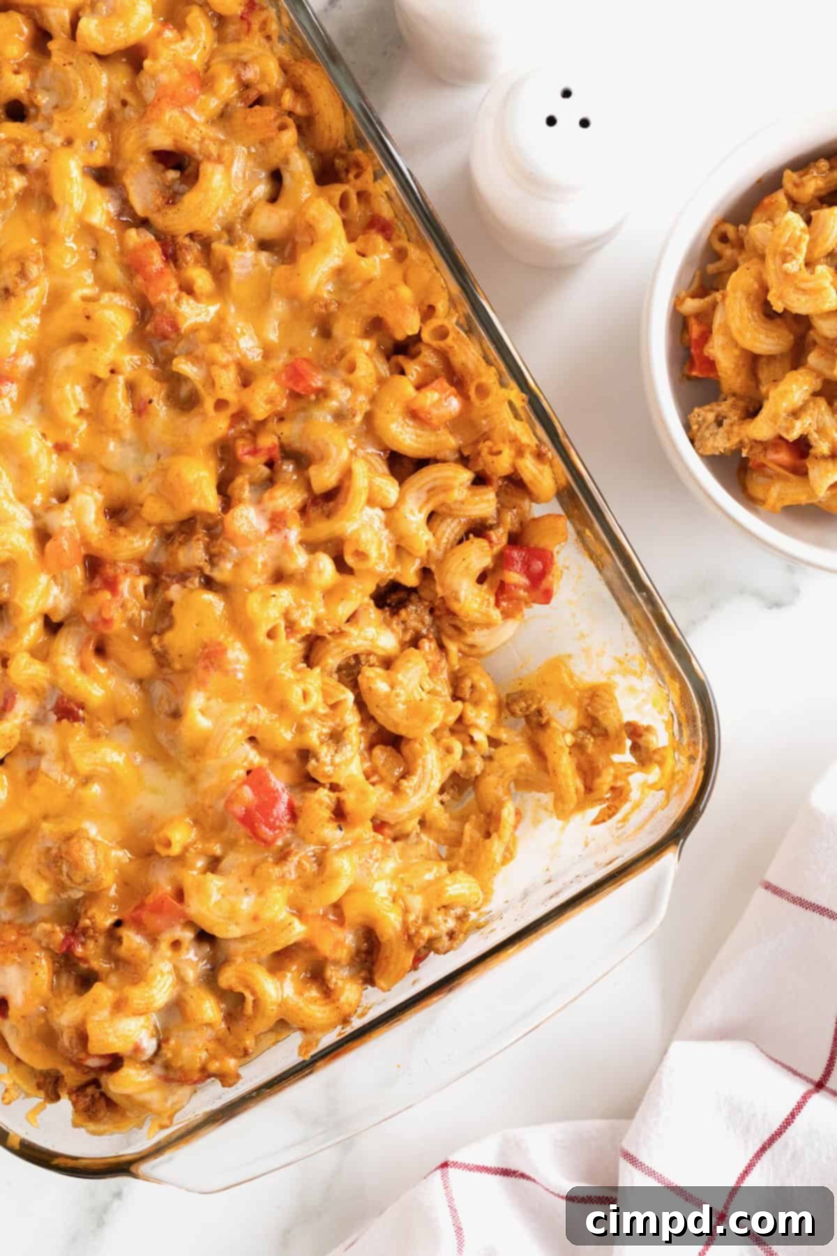 Fiesta Mac and Cheese 2 A glass casserole dish with Mexi Mac and cheese on a white marble counter, ready to be served.