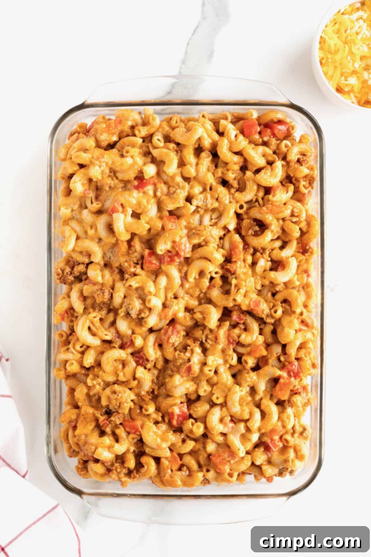 Fiesta Mac and Cheese 12 A 9x13 glass baking dish filled with the creamy Mexican macaroni casserole, ready for baking.