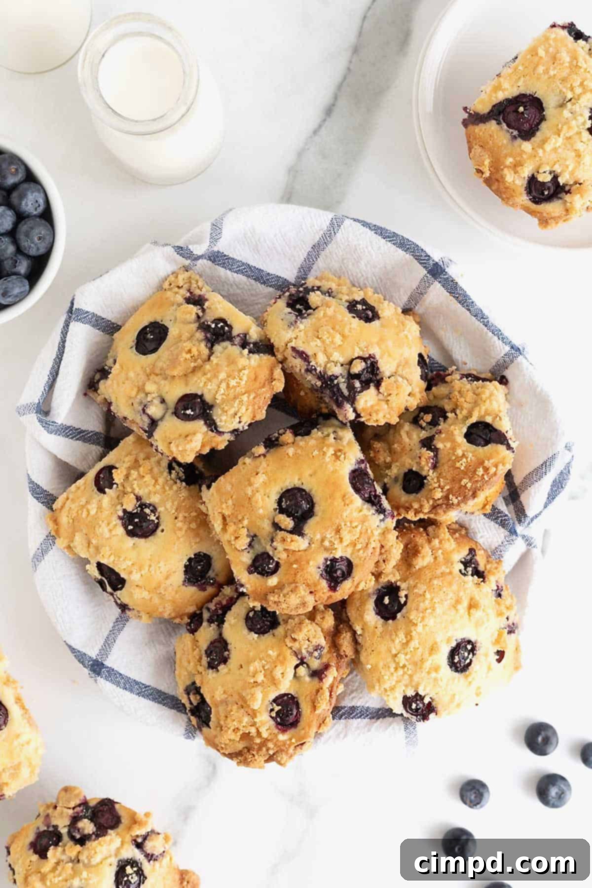 A basket full of golden-brown blueberry streusel muffins, showcasing their crispy streusel topping and vibrant blueberry bursts.