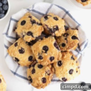 A basket full of golden-brown blueberry streusel muffins, showcasing their crispy streusel topping and vibrant blueberry bursts.
