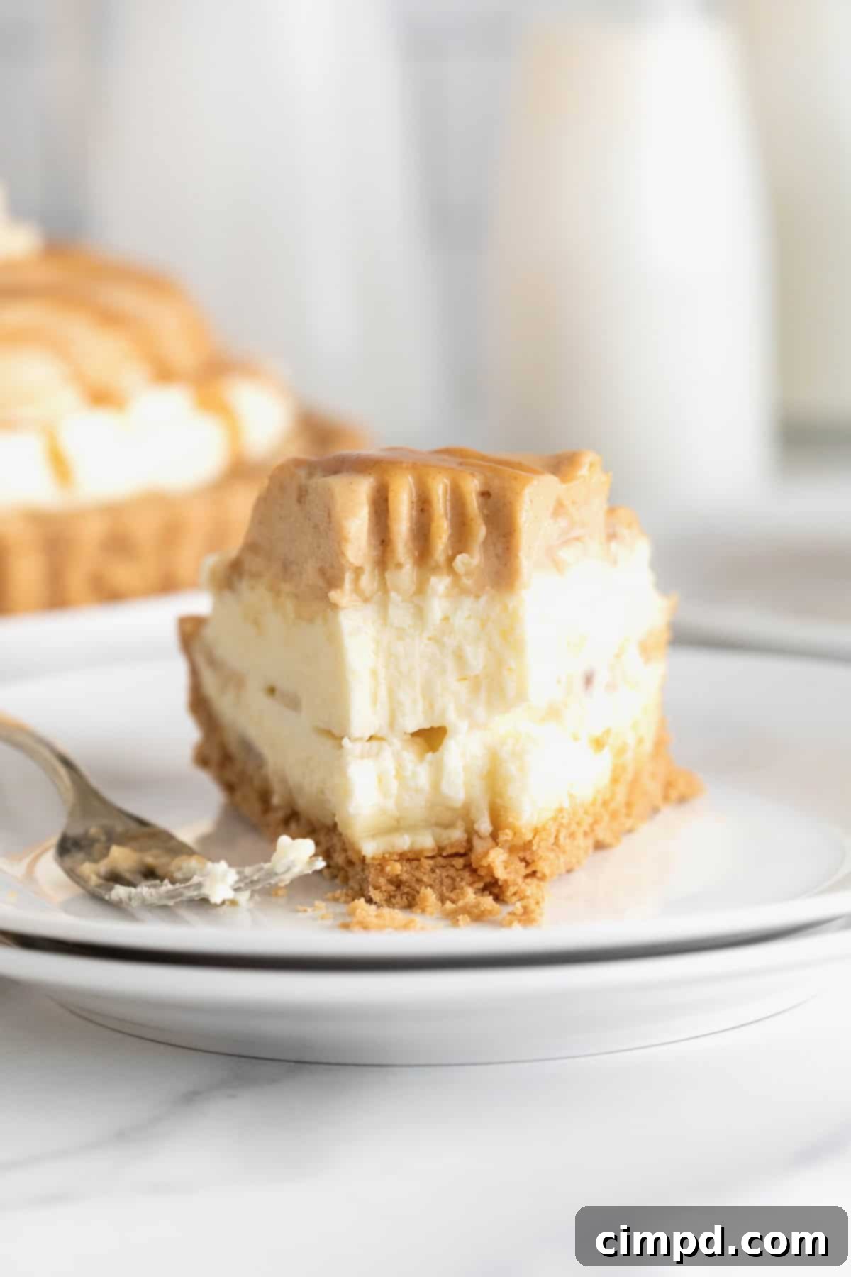 A slice of peanut butter banana cream pie with a bite taken out of it.