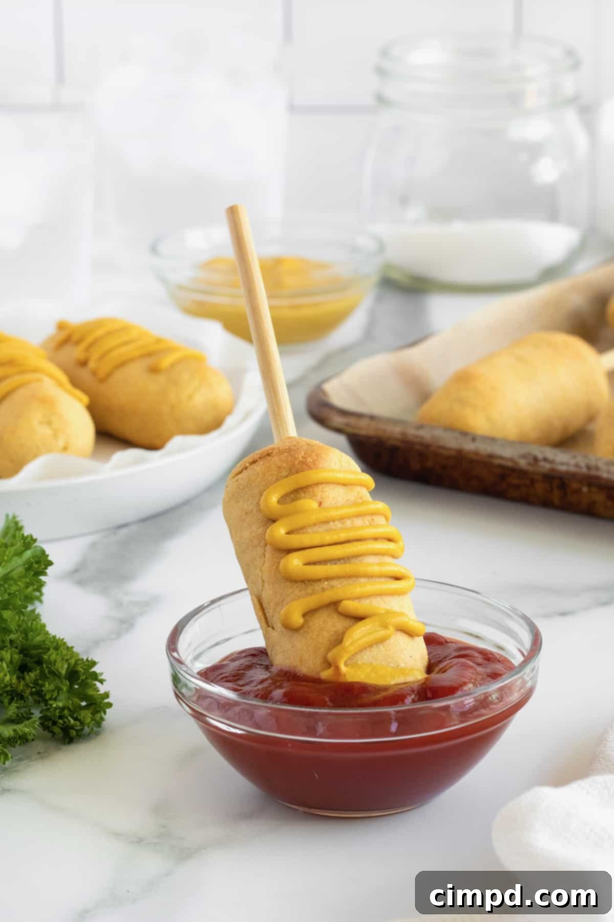 Golden brown baked corn dogs on a stick, ready to serve, representing a healthy take on a state fair classic.