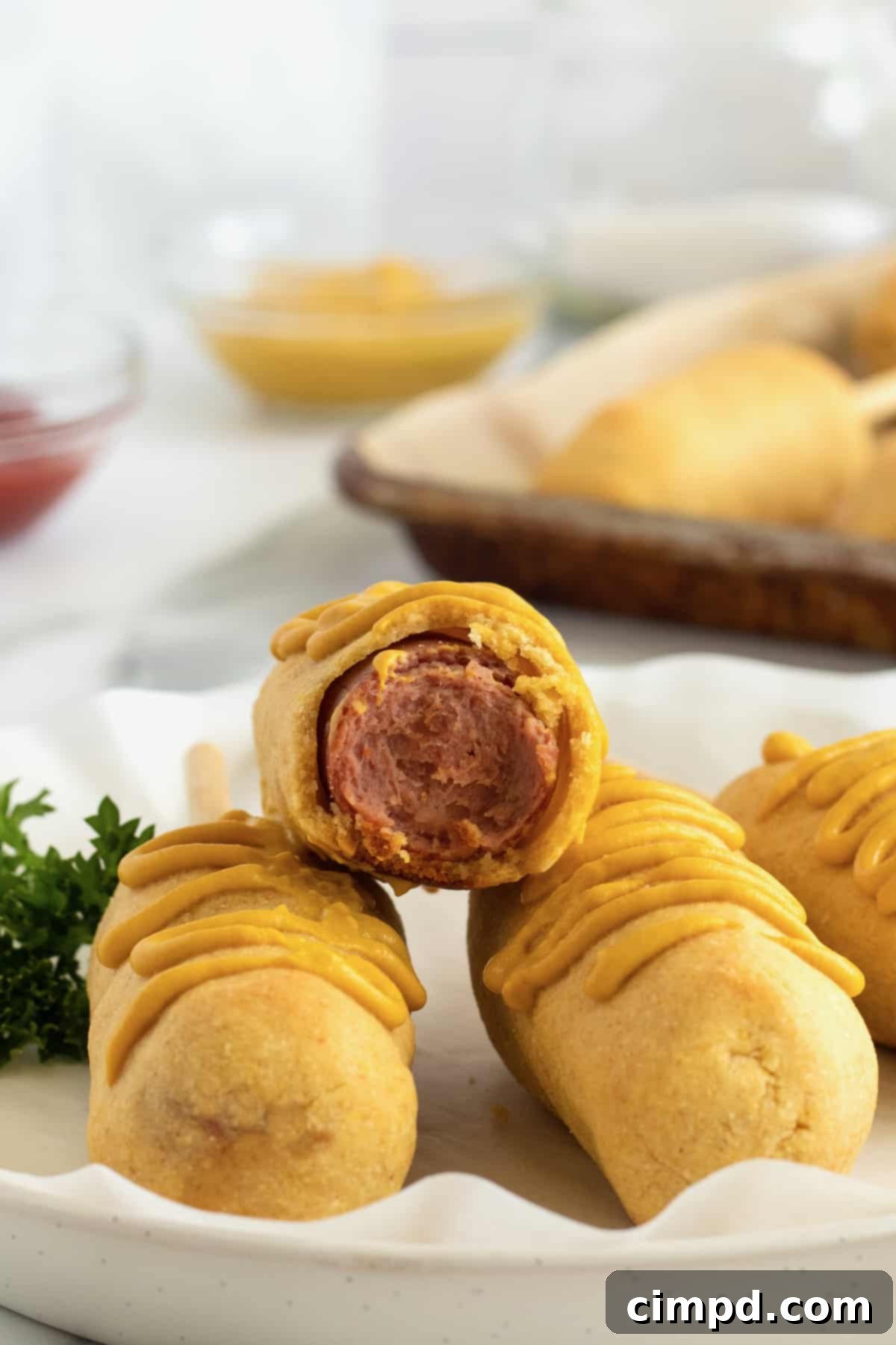 Freshly baked corn dogs on a serving platter, showcasing their golden-brown, crispy exterior.