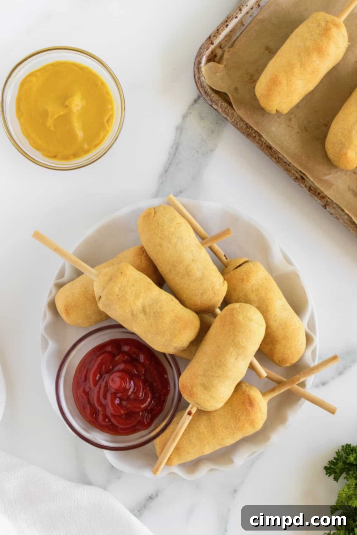 Close-up of a baked corn dog with a golden crust, showing the texture of the cornmeal batter.