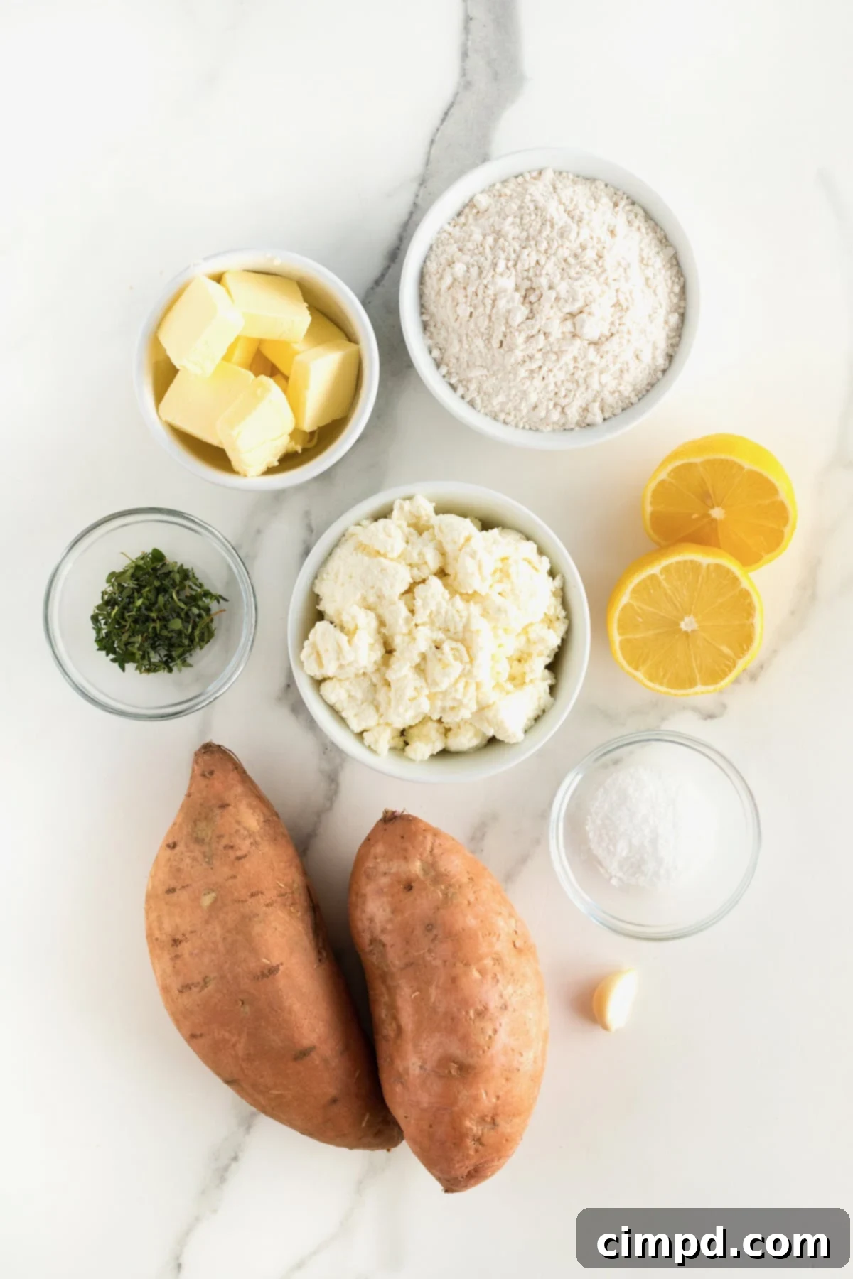 A collection of fresh ingredients for sweet potato gnocchi, neatly arranged in small glass bowls on a white marble countertop.