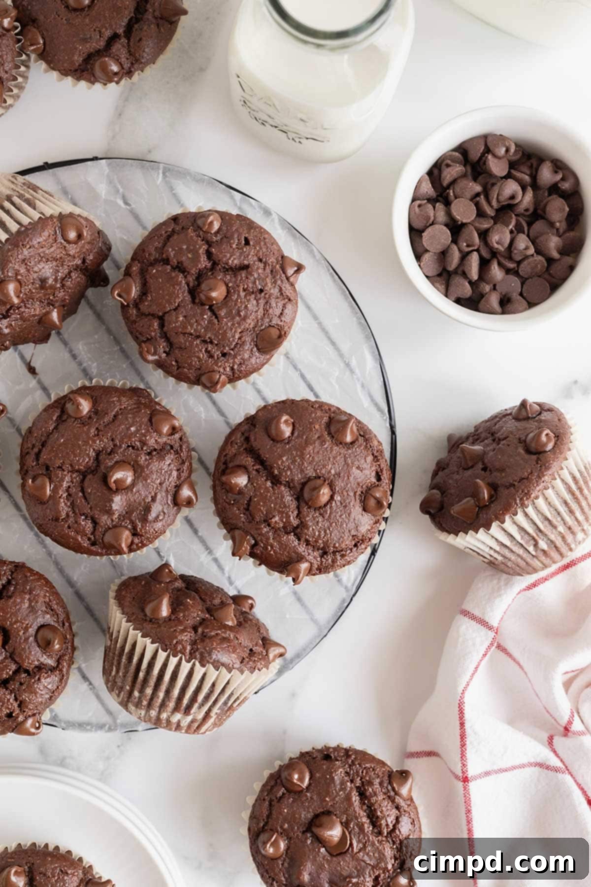 A round wire cooling rack scattered with freshly baked Healthier Double Chocolate Muffins, ready to be enjoyed.