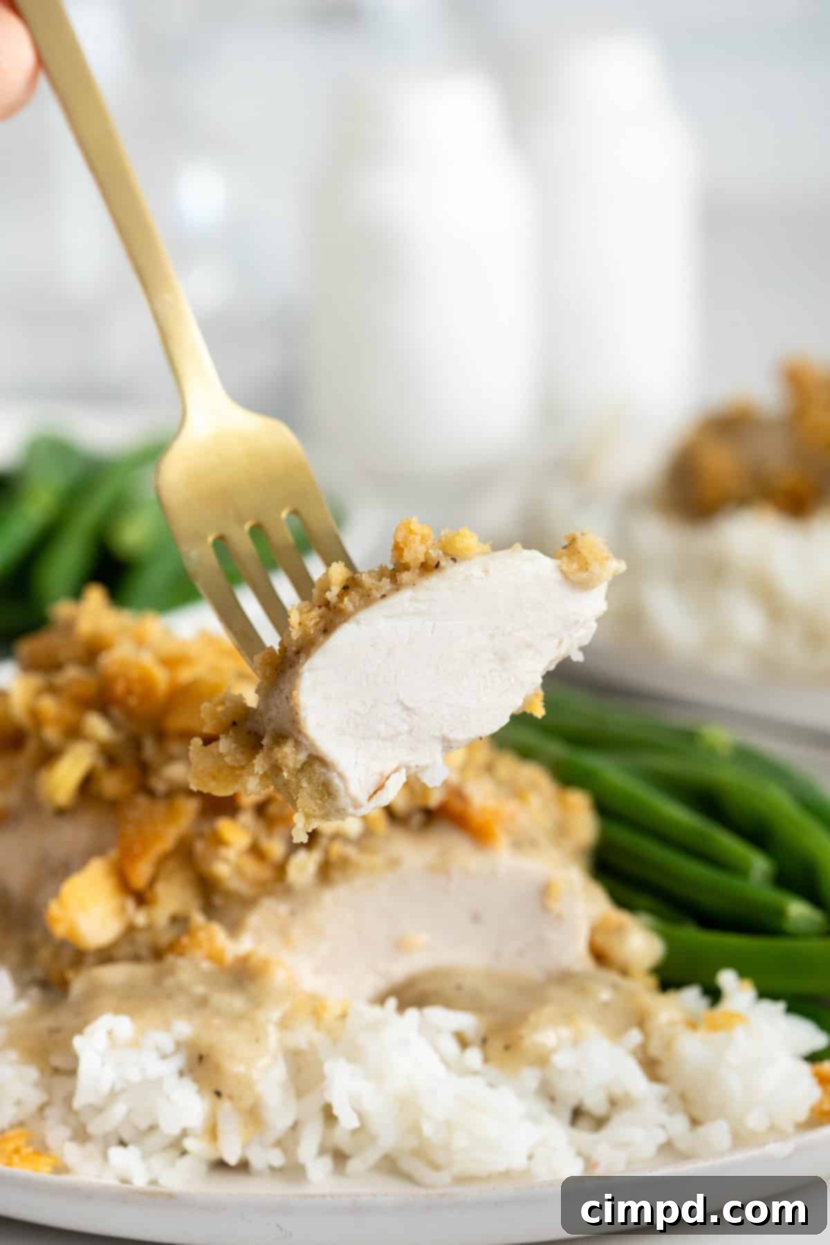 A fork holding a perfect bite of creamy chicken bake, showcasing the tender chicken, rich sauce, and crunchy cracker topping.