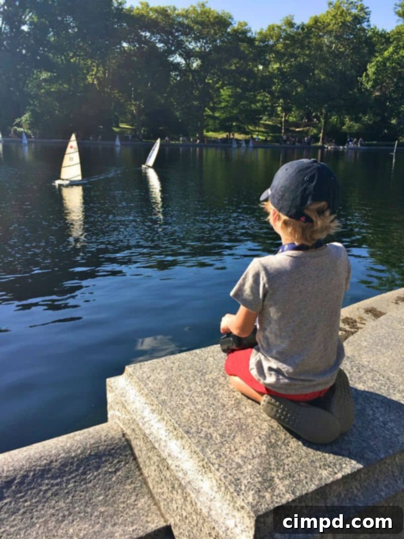 Two boys happily sailing remote-control boats on a pond