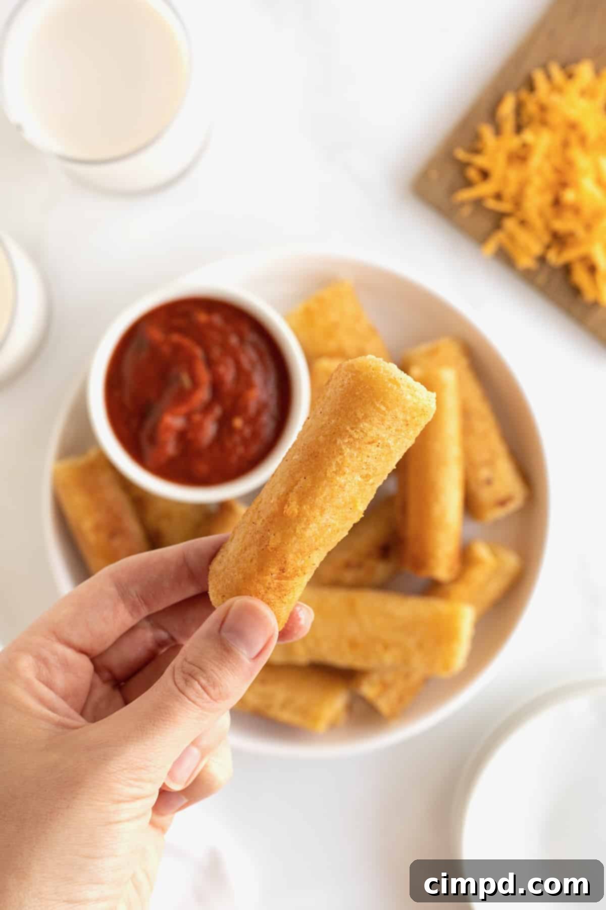 A beautiful close-up of several perfectly grilled cheese roll ups, showcasing their golden-brown, crispy exteriors, arranged invitingly on a white serving plate, ready to be enjoyed.