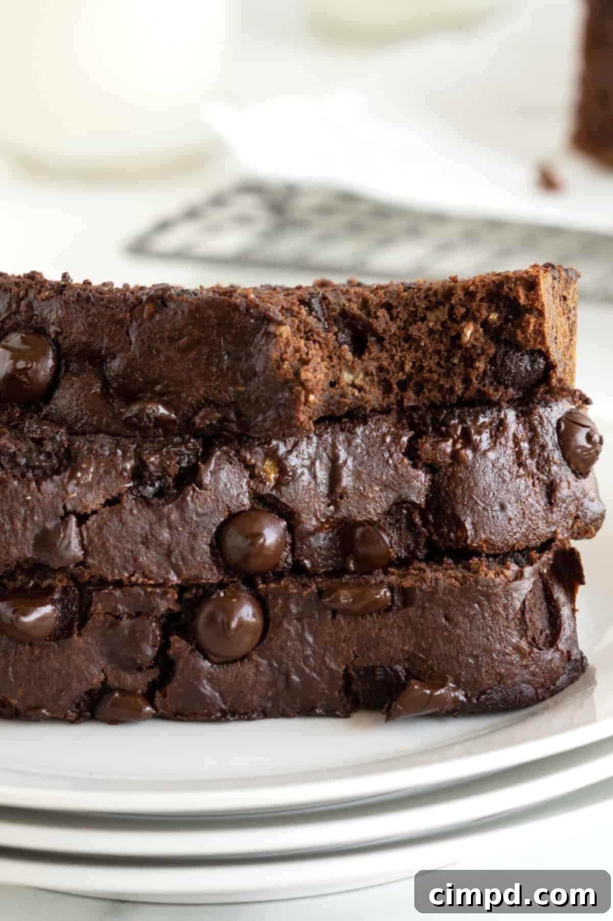 Guilt-Free Chocolate Banana Loaf 11 Three slices of healthy chocolate banana bread neatly arranged on a white ceramic plate, ready to be enjoyed.