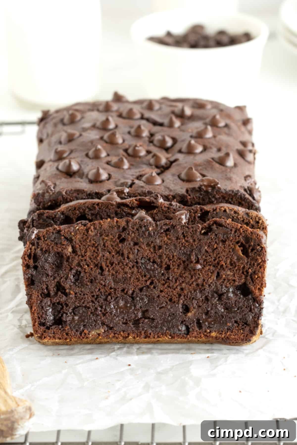 Guilt-Free Chocolate Banana Loaf 5 A close-up of a loaf of healthy chocolate banana bread being sliced, revealing its moist interior and chocolate chips.