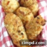 A close-up of a stack of golden crispy baked chicken tenders, garnished with fresh parsley.