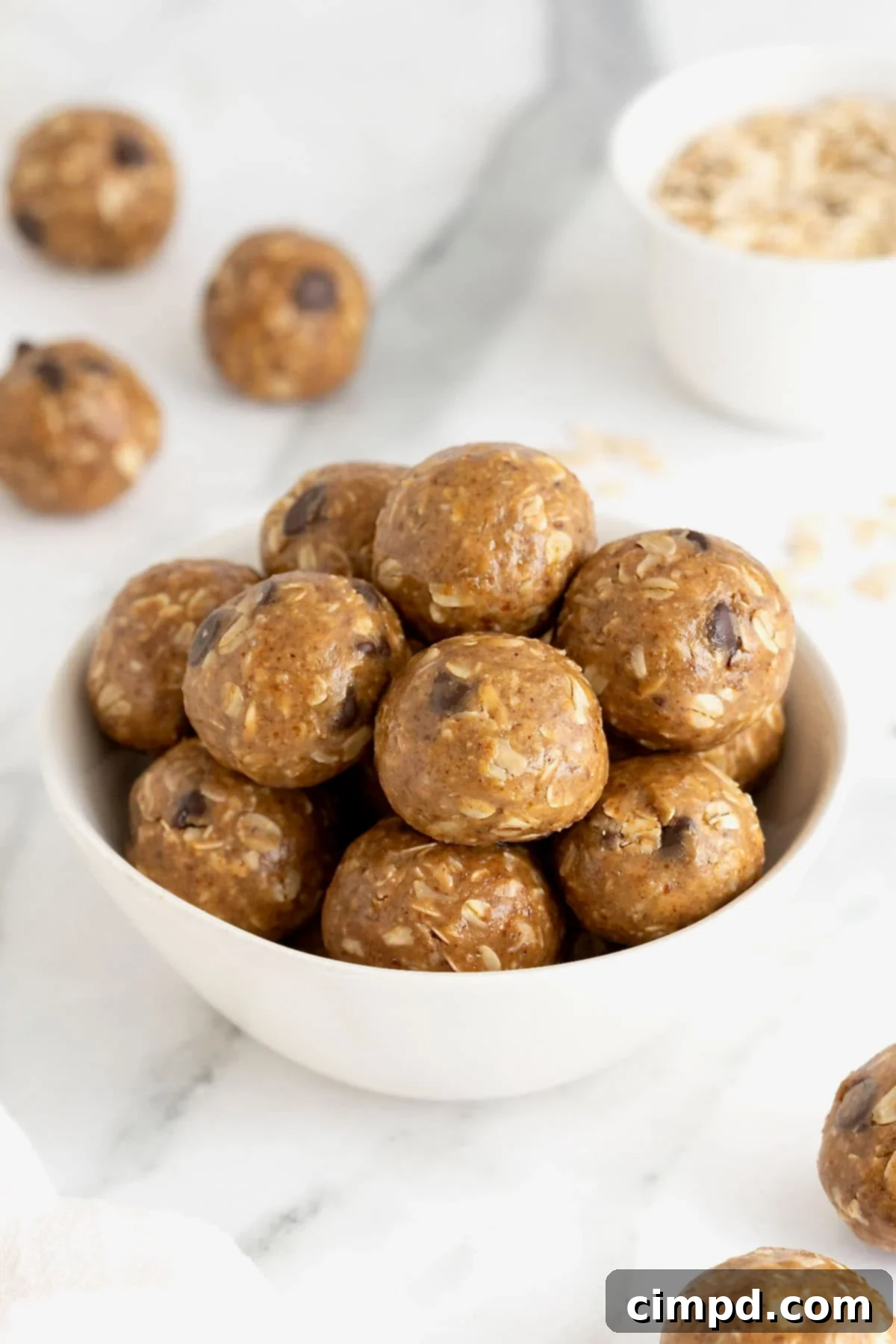 A white bowl of snack bites with chocolate chips in them.