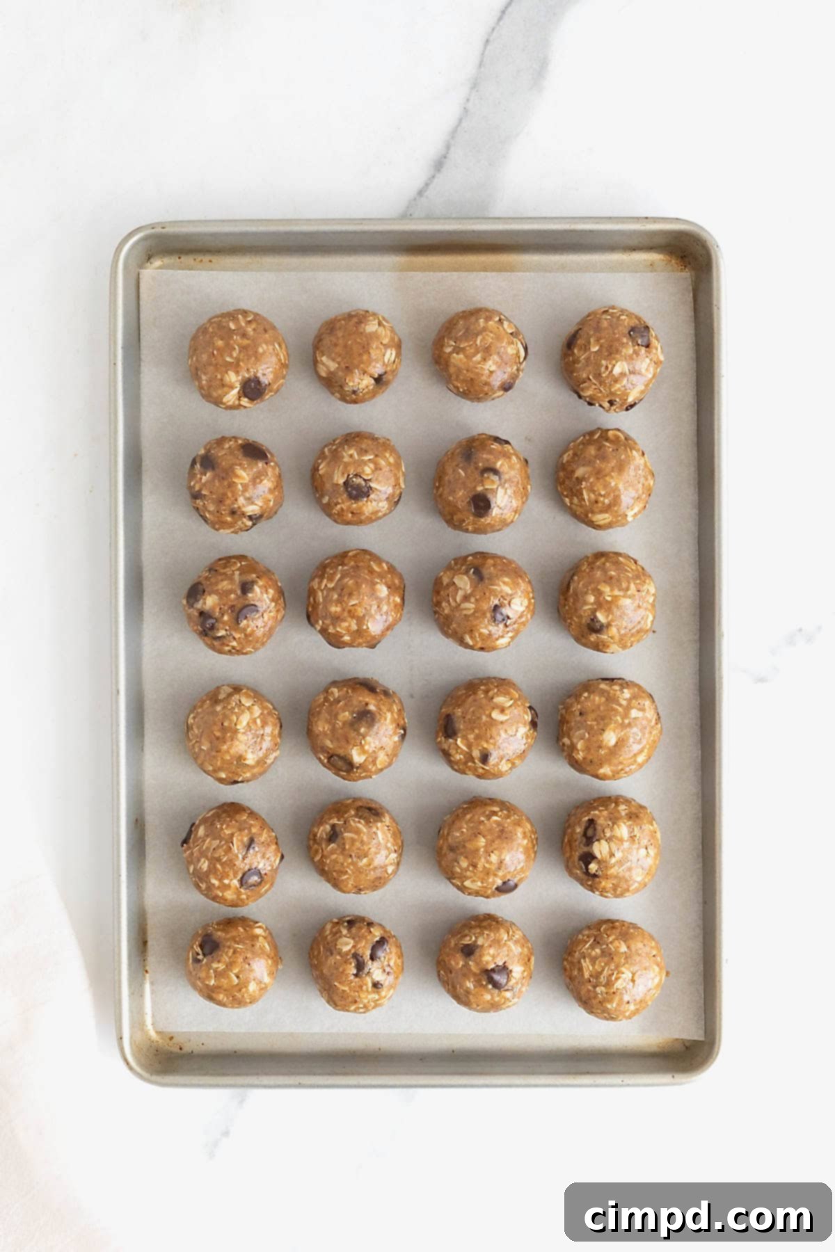 24 lactation bites on a parchment lined baking sheet.