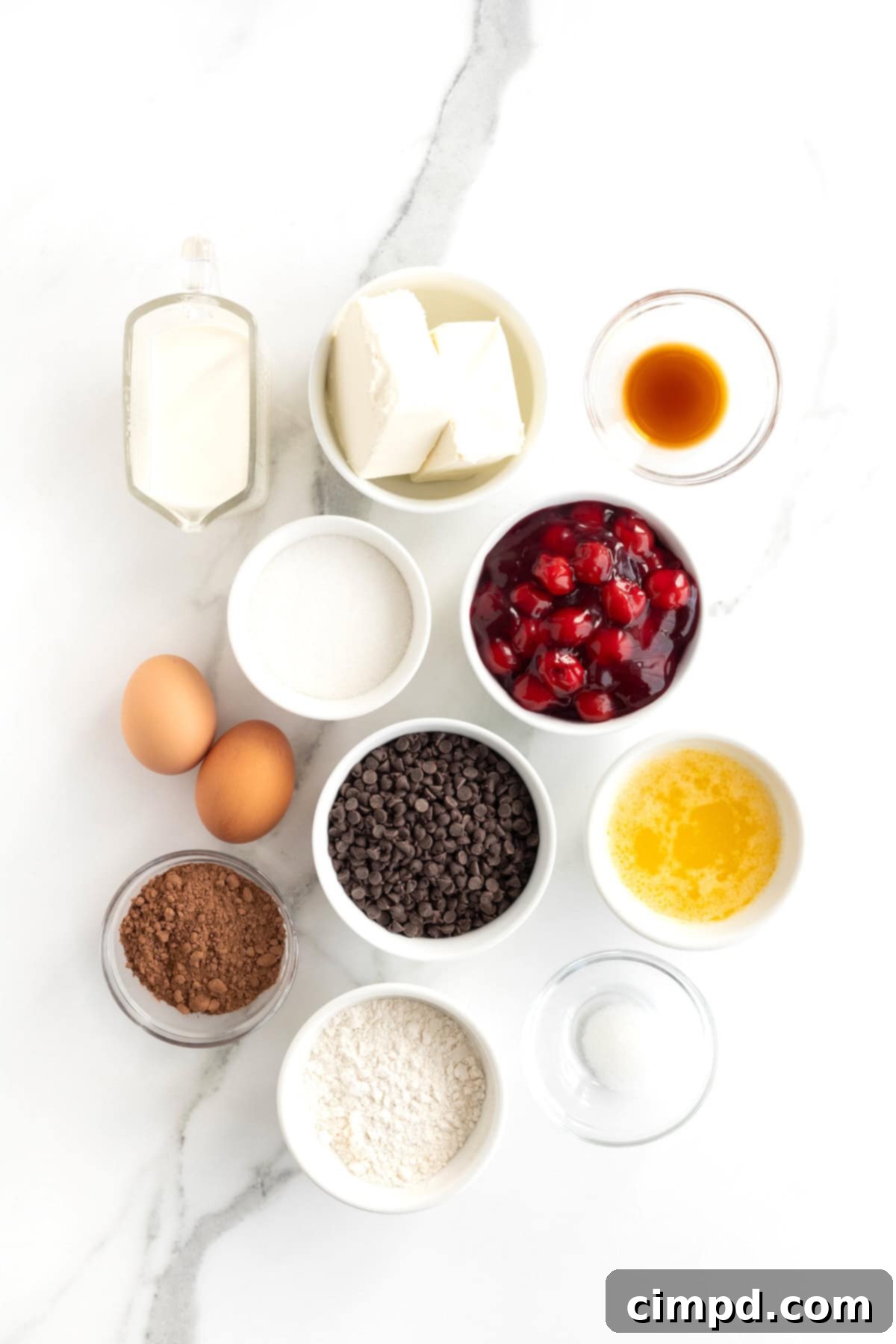 All the necessary ingredients laid out in small white glass dishes on a white marble counter, ready to make Cherry Chocolate Chip Cheesecake Brownie Bites.