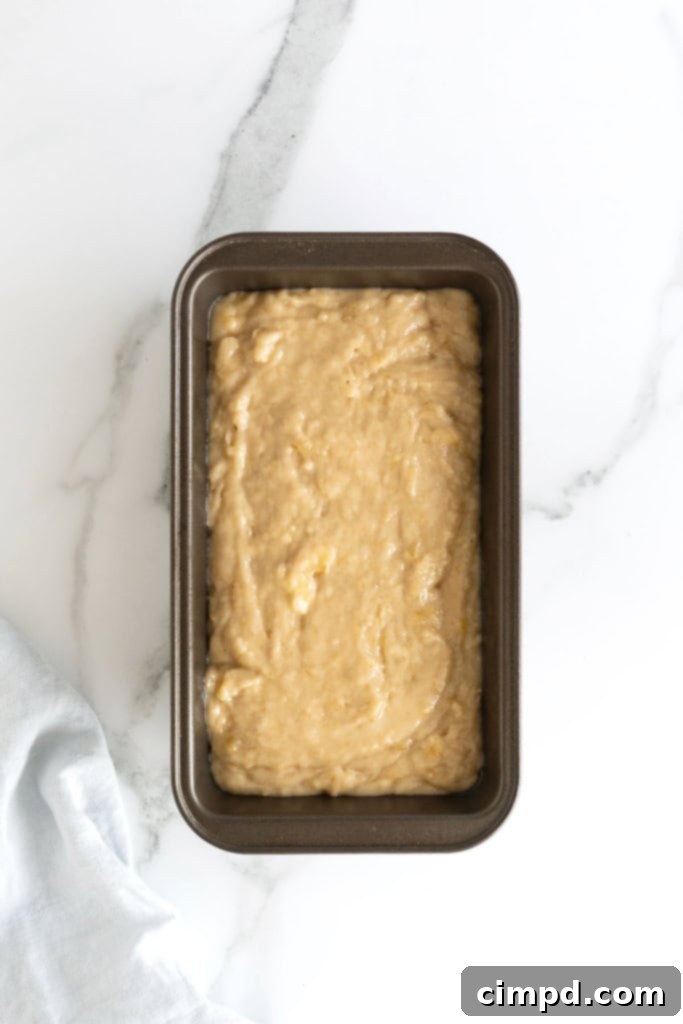 Next Level Brown Butter Banana Bread 9 Banana bread batter in a dark aluminum loaf pan.