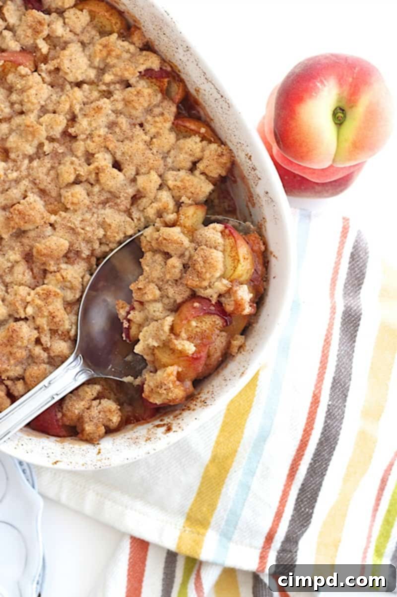 Snickerdoodle Peach Cobbler drizzled with a light sauce, ready for serving