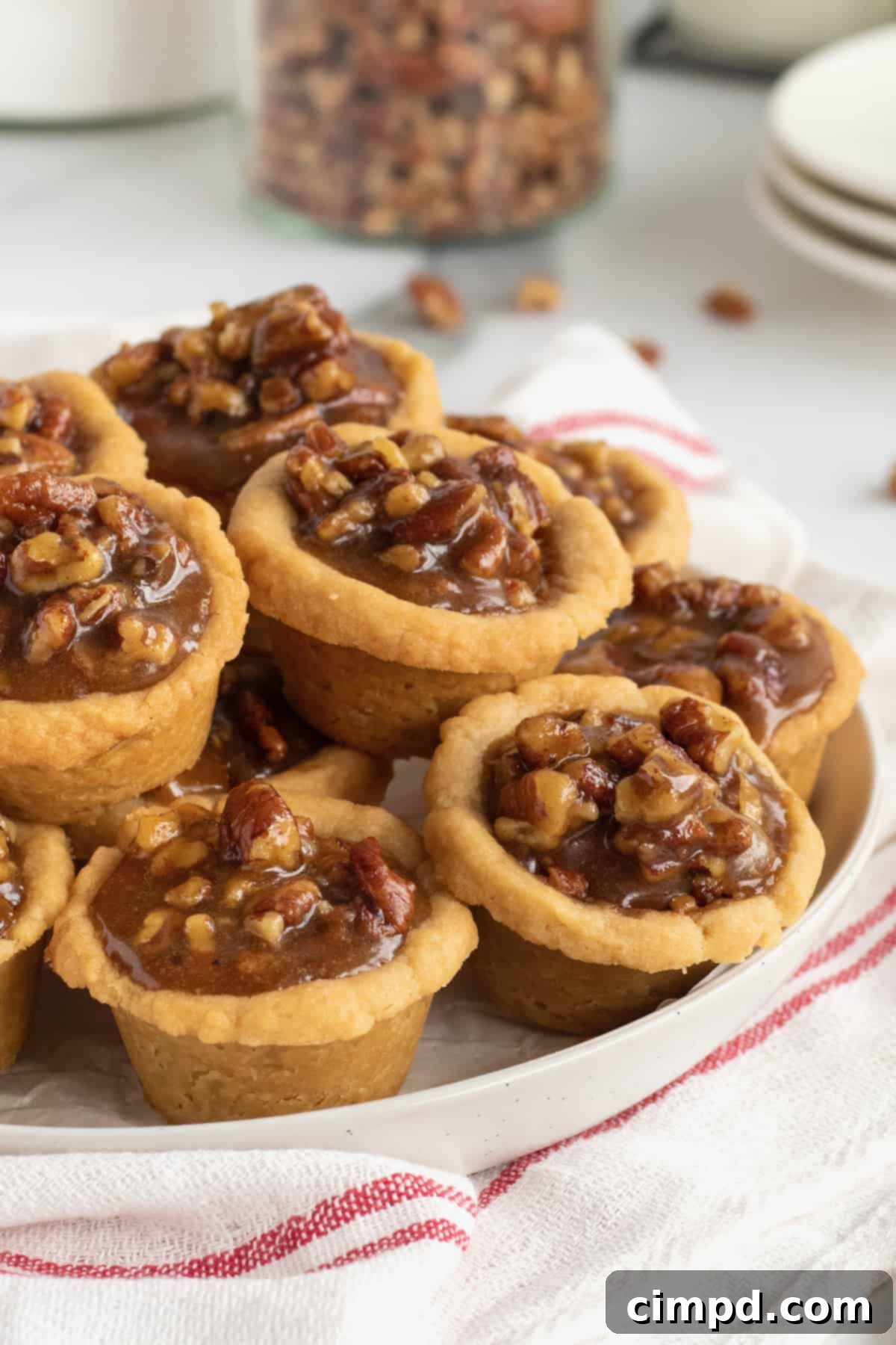 Golden brown Pecan Pie Bites on a white platter, ready to be served, perfect for holiday gatherings.