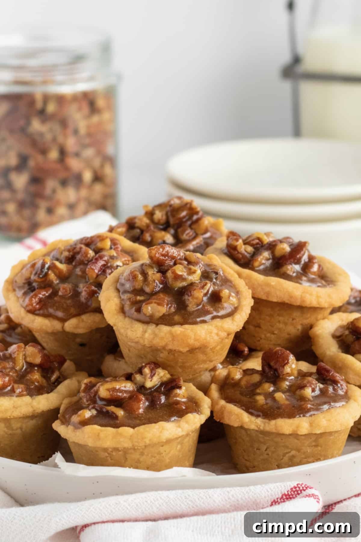 A beautifully arranged stack of golden Pecan Pie Bites on a rustic wooden board, ready for a holiday dessert table.