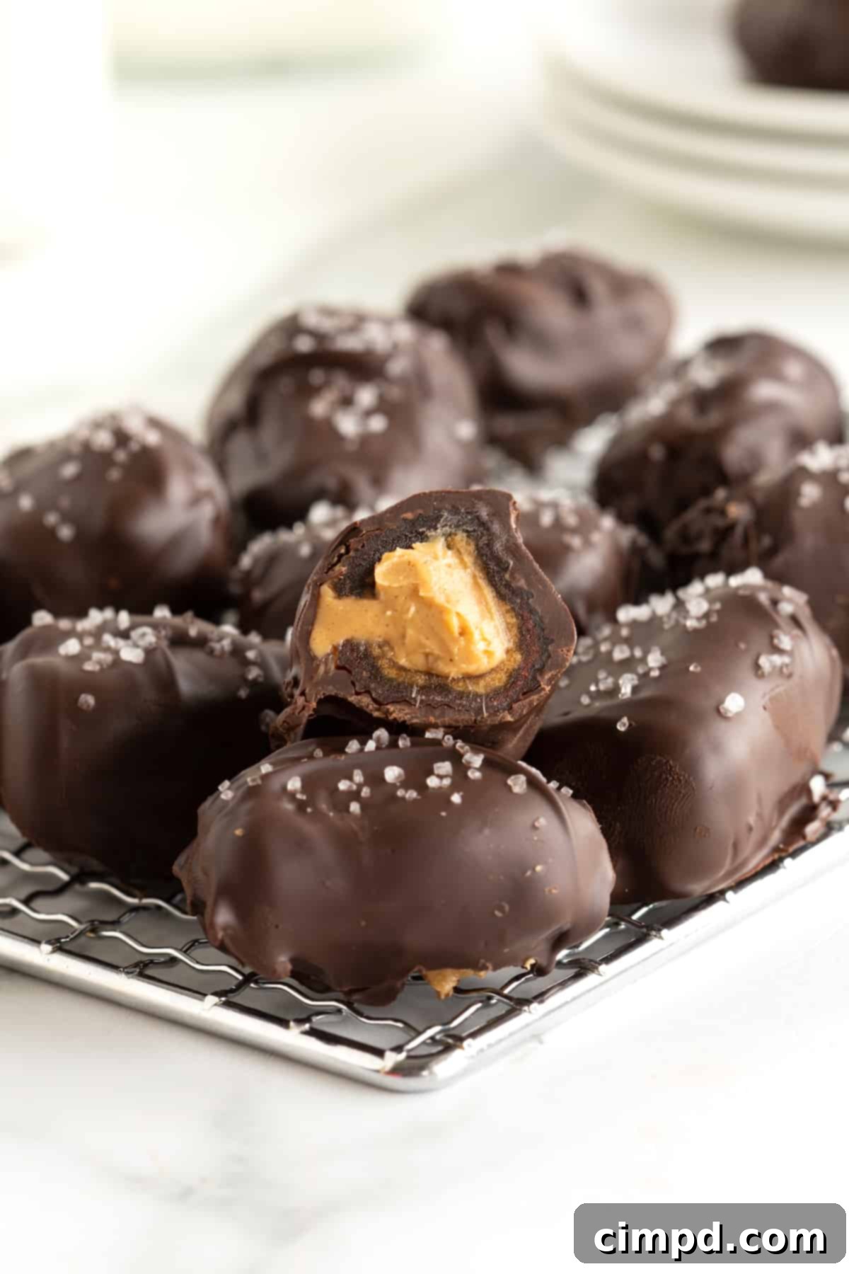 Salted Dark Chocolate Peanut Butter Stuffed Dates 2 Stuffed dates on a wire rack on the counter.