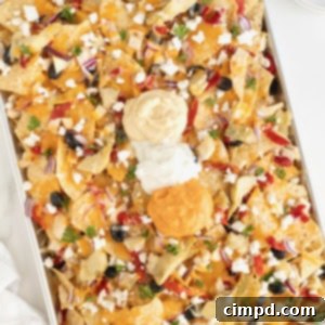 A sheet pan full of pita chip nachos on a white marble counter.