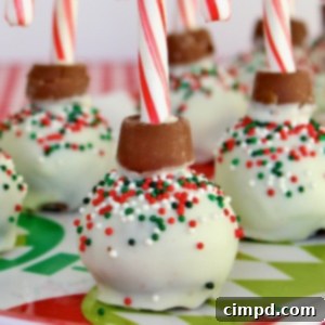 Christmas treats that look like ornaments, with a mini candy cane on top.