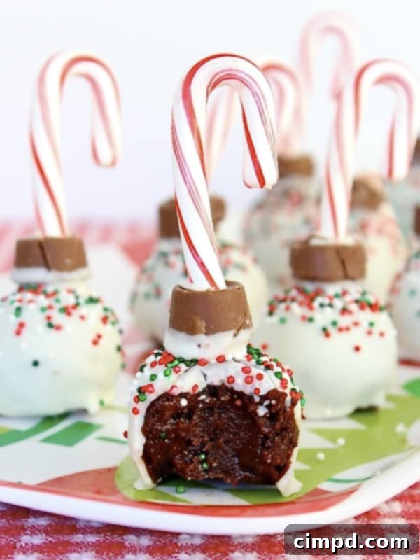 A close-up of an Ornament Brownie Ball with a bite taken out, revealing its rich, fudgy interior and smooth white coating.