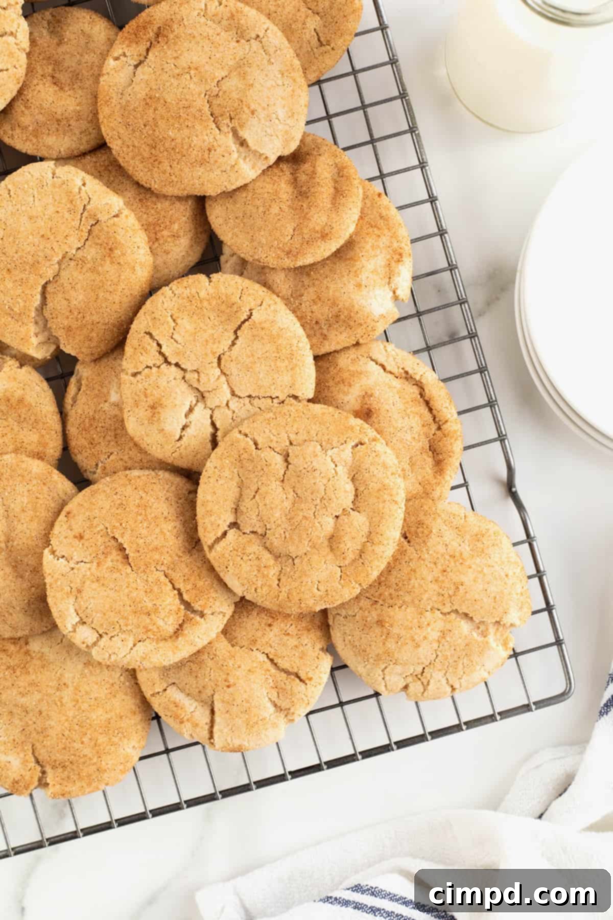 A wire cooling rack filled with warm, freshly baked gingerdoodle cookies, ready to be enjoyed.