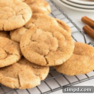 A close-up image of Chewy Gingerdoodle Cookies stacked on a wire cooling rack.