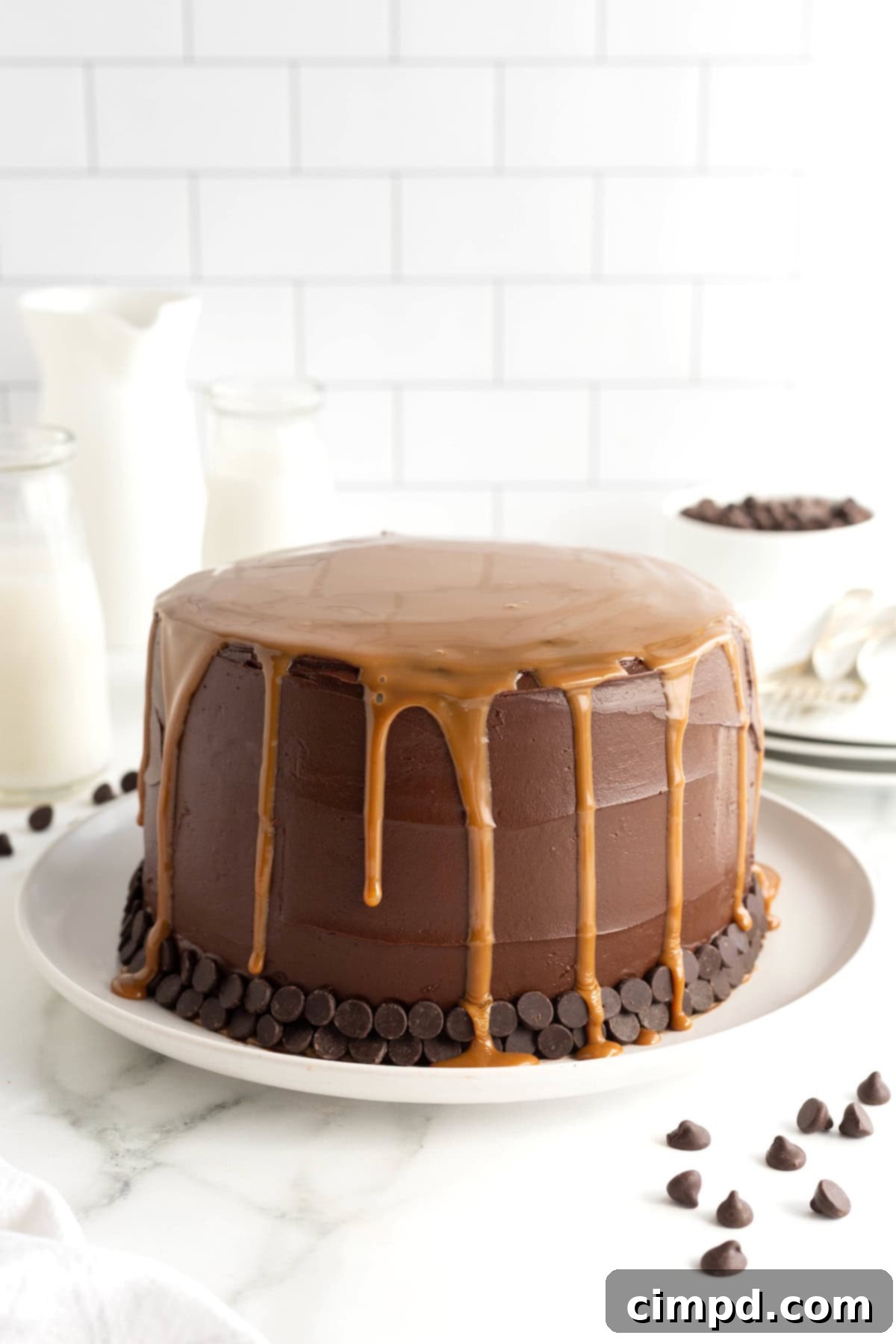 A close-up shot of a richly frosted chocolate cake, with thick, glossy caramel expertly drizzled and gracefully flowing down its sides, creating an inviting cascade.