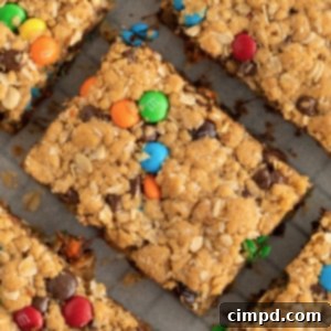 A top-down view of perfectly baked Flourless Monster Cookie Bars, showcasing their colourful toppings and chewy texture.