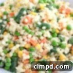 A small bowl of colorful baby pasta salad, ideal for self-feeding, shown from an overhead perspective.