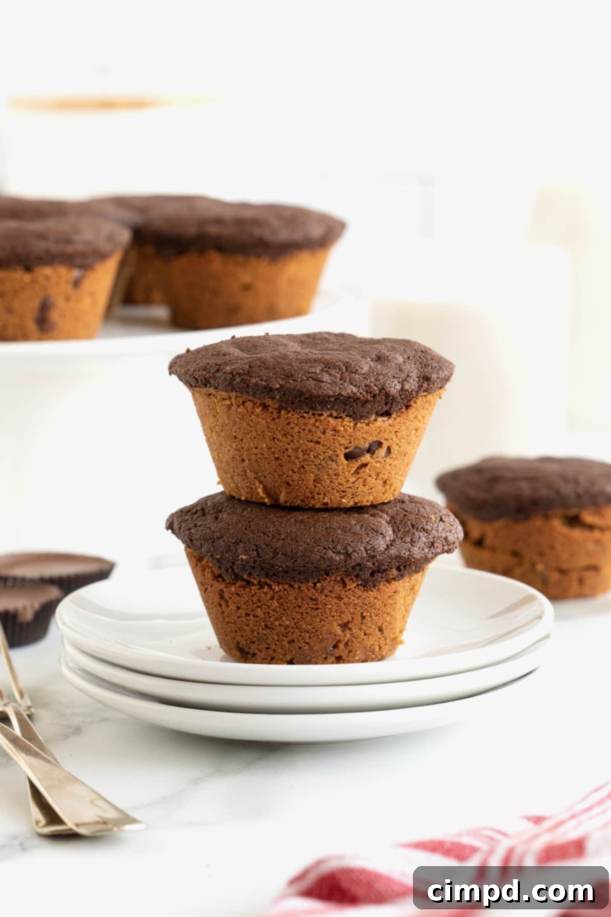 Two brookies stacked on top of each other on top of a small white plate, showing their perfectly baked tops.
