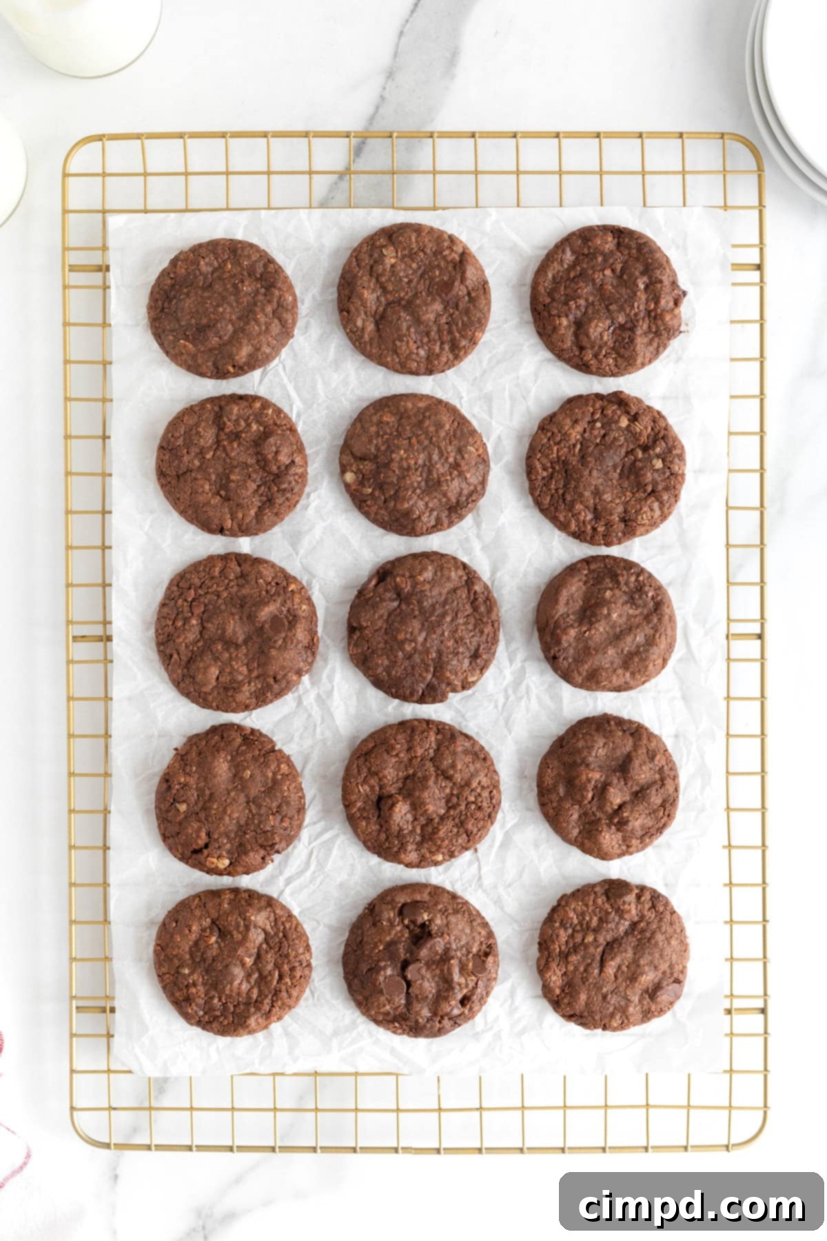 15 Nutella cookies cooling on a parchment lined metal rack.