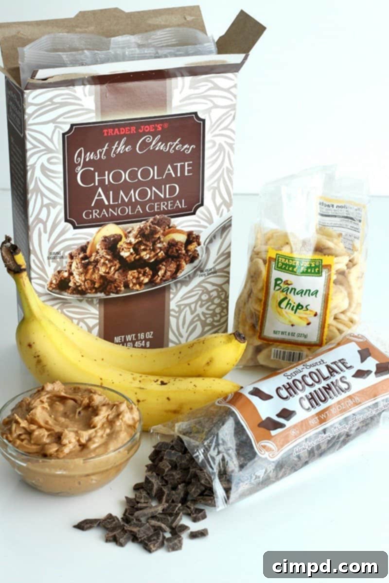 Assortment of ingredients for No-Bake Chunky Monkey Granola Bars, including chocolate granola, peanut butter, and bananas