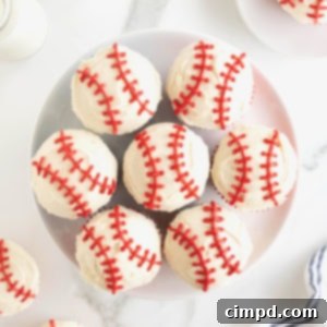 A large round white plate filled with baseball cupcakes, ready to be served at a party.