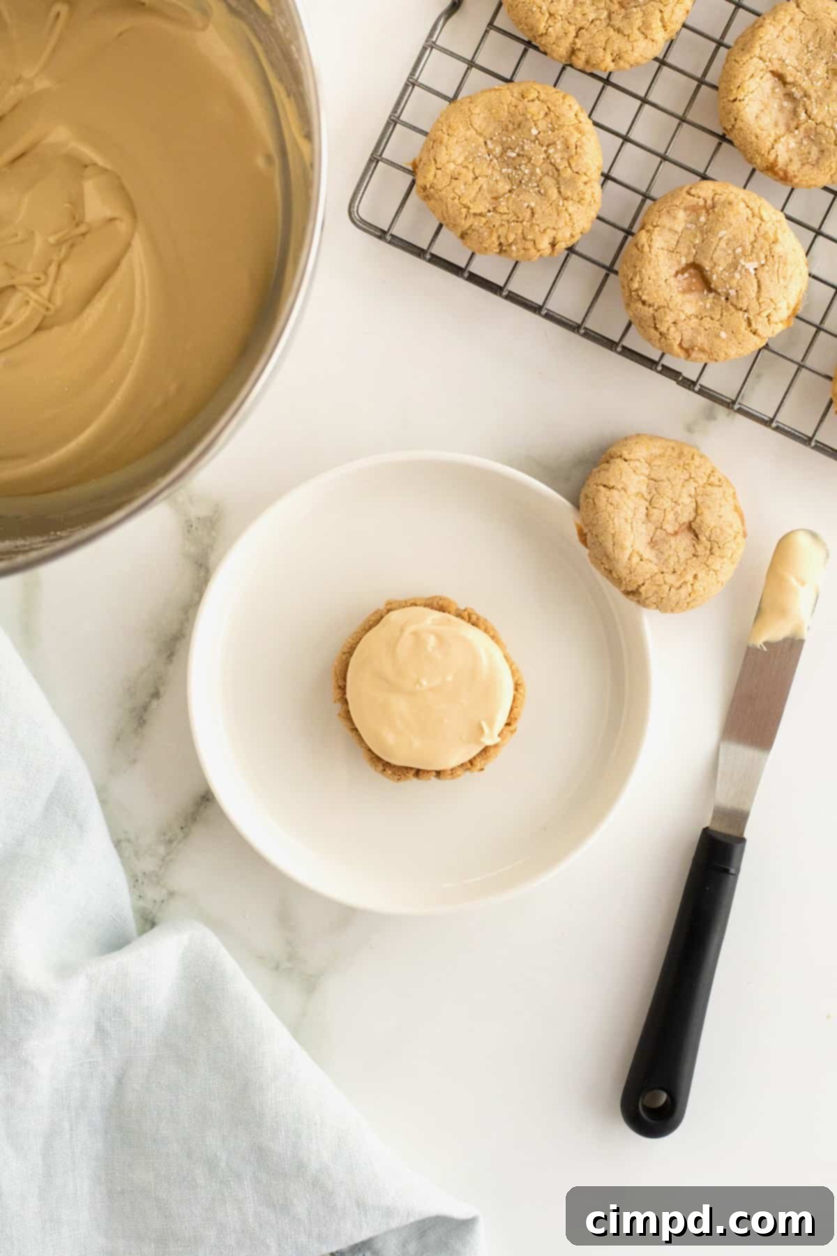 An oatmeal cream pie base with a generous dollop of creamy filling, awaiting its top cookie.