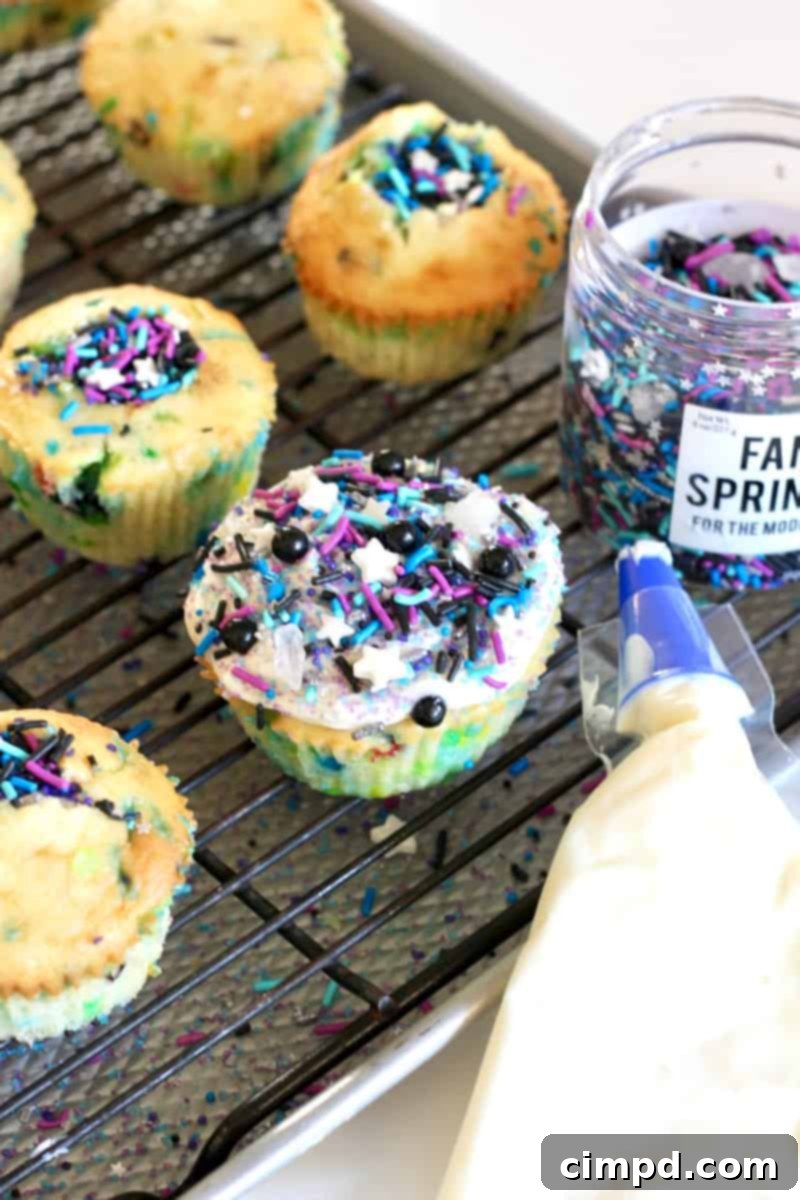 Close-up of a hand reaching for a Cosmic Cupcake with a surprise inside