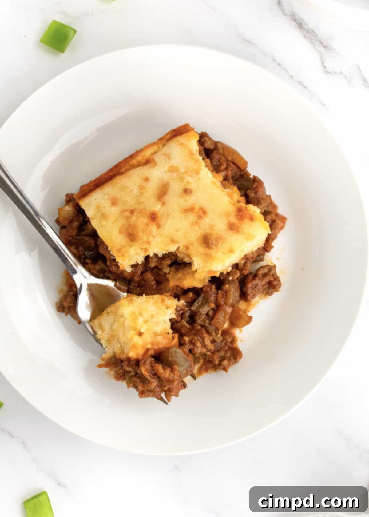 Sloppy Joe Supper Bake 7 A generous serving of Sloppy Joe Casserole, freshly baked and topped with melted cheese, on a plate ready to be enjoyed.