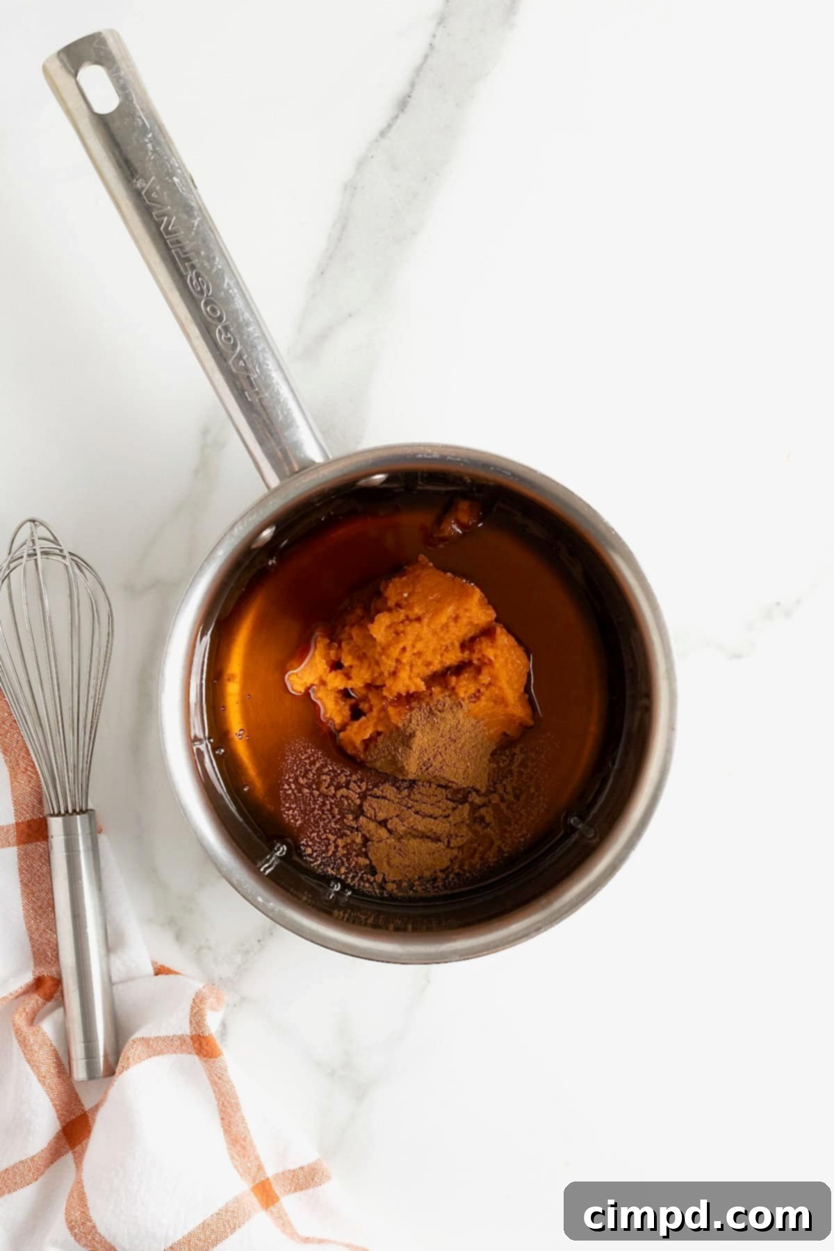 Autumn Pumpkin Banana Pancakes with Pumpkin Spice Drizzle 11 Pumpkin puree, maple syrup and pumpkin spice in a metal saucepan.