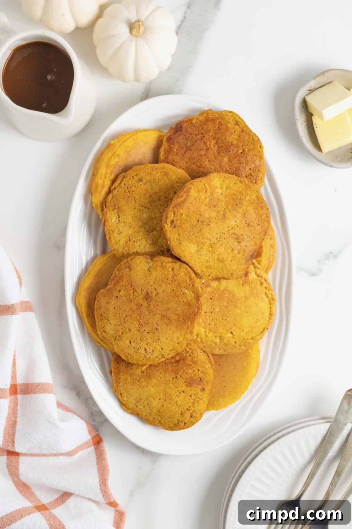 Autumn Pumpkin Banana Pancakes with Pumpkin Spice Drizzle 14 A white oblong plate of pumpkin banana pancakes.