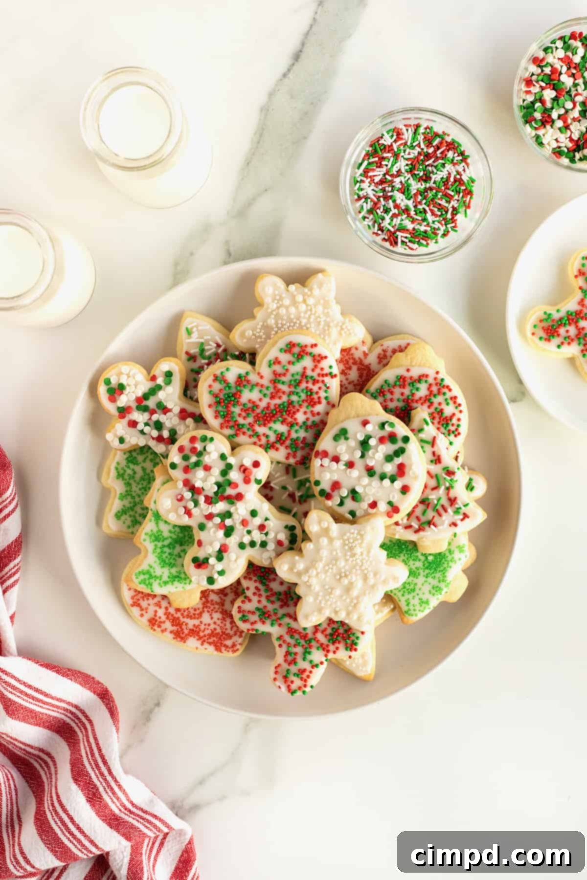 A large white plate filled with Christmas sugar cookies.