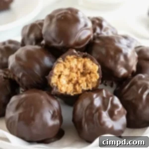 A pile of dark chocolate peanut butter balls in a parchment lined white serving dish.