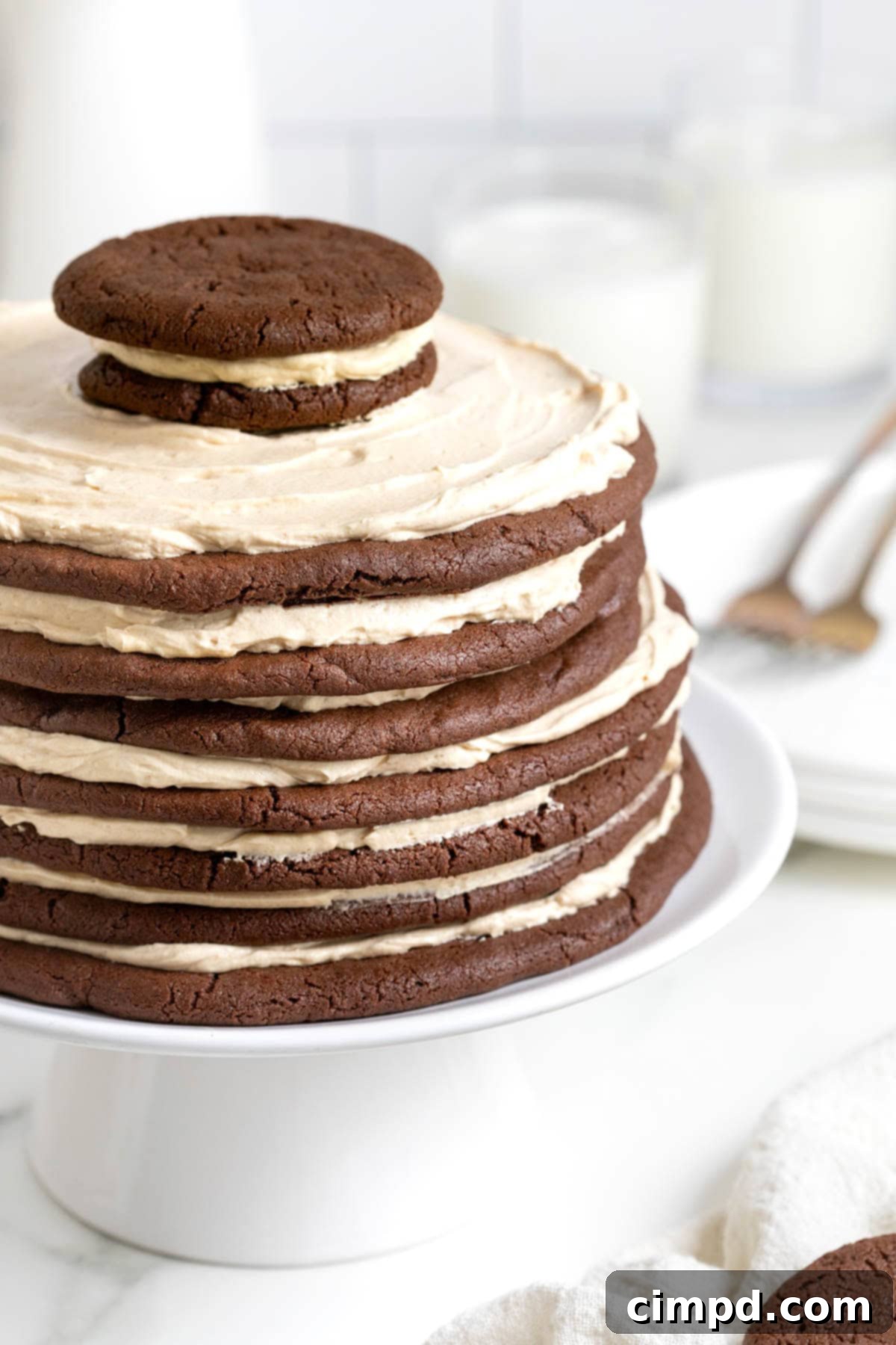 Decadent Peanut Butter Chocolate Cookie Tower 2 A chocolate peanut butter layered cookie cake, beautifully arranged on a pristine white cake stand, showcasing its decadent layers.