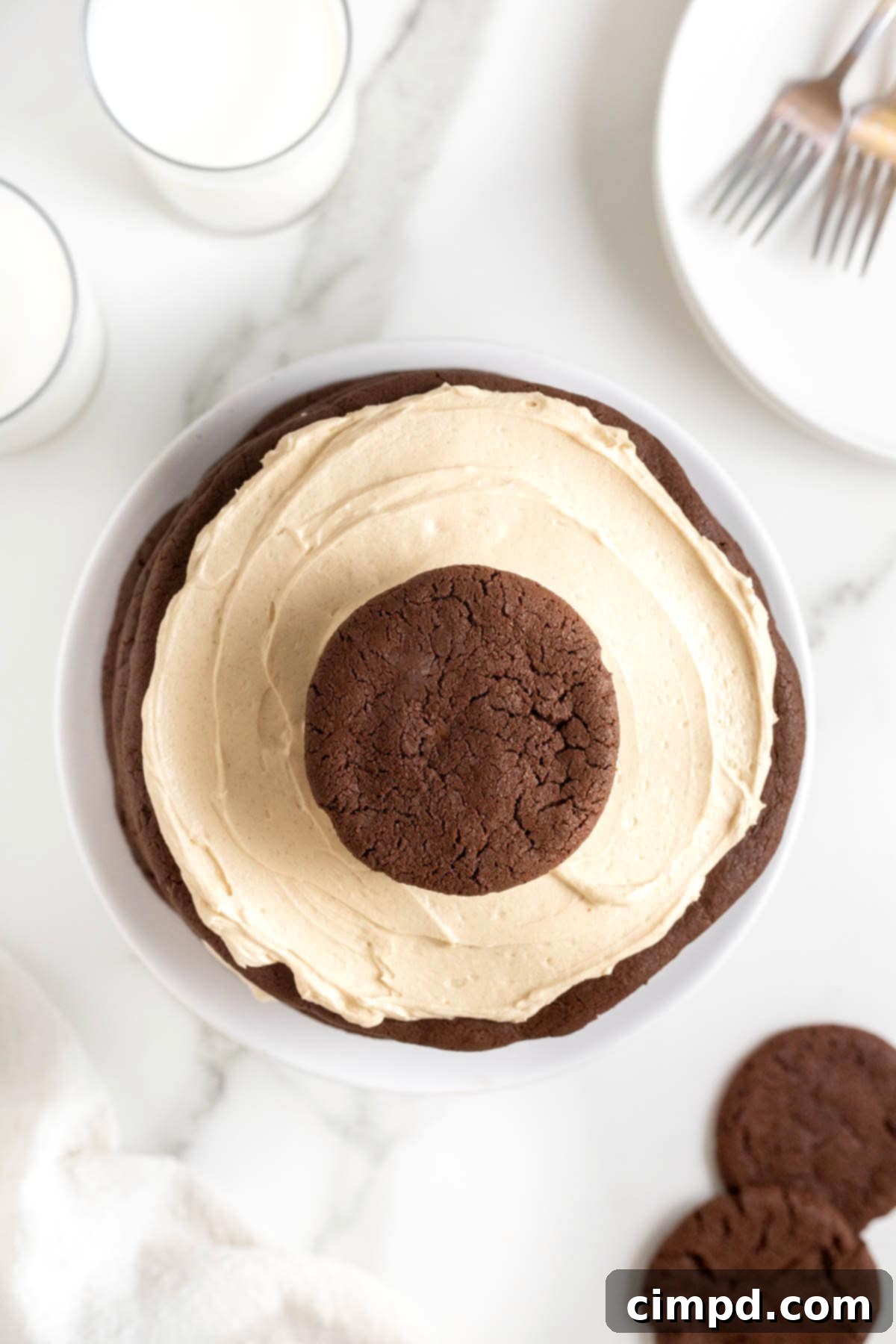 Decadent Peanut Butter Chocolate Cookie Tower 12 An aerial view of the finished chocolate peanut butter layered cookie cake, impeccably decorated and sitting on a white cake stand on a white marble surface.
